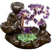 Decorative incense burner with purple and green stones on a white background