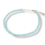 Turquoise beaded anklet with a gold clasp on a white background