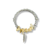Bracelet with stone beads and feather charm on a white background
