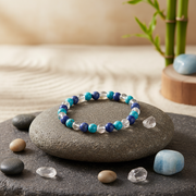 Glowing blue bracelet on a stone with pebbles and bamboo in the background