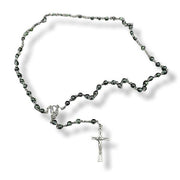 Green rosary necklace with a cross pendant on a white background