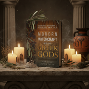 Book titled 'Modern Witchcraft with the Greek Gods' on a table with candles and decorative items.