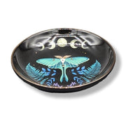 Decorative ceramic plate with a lunar moth design on a black background