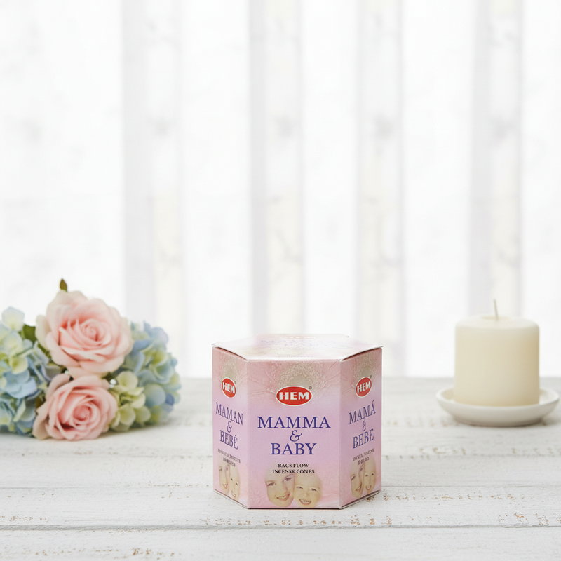 HEM Mamma & Baby product packaging on a white surface with flowers and a candle in the background