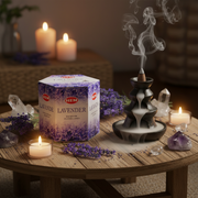 HEM Lavender incense box with incense cone burner, candles, and lavender flowers on a wooden table.