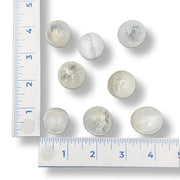 White spherical selenite stone beside a ruler for size