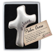 Silver palm cross with 'Believe' engraved, in a box with a card detailing its message.