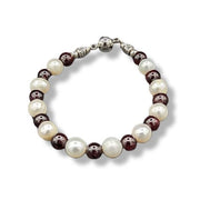 Bracelet with alternating brown and white beads on a white background
